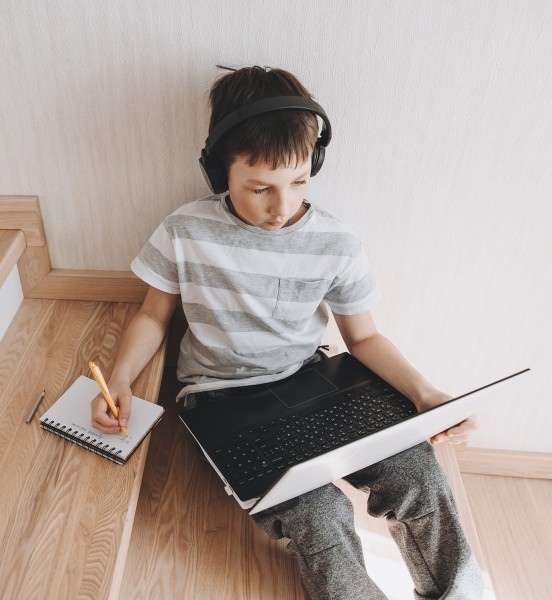 teenage-boy-in-wireless-headphone-sitting-on-steps